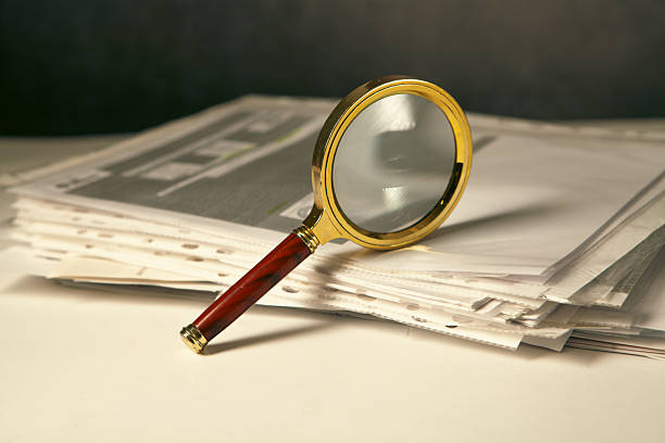 Magnifying glass resting on research publications